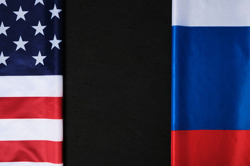 Flags of the United States of America and the Russian Federation are opposite each other on a black background.