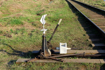 Railway arrow in black with a lever and pointer in Russia. The device for the transfer of rails at intersections for trains. Technical element of the railway industry.