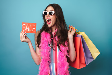 Poster - Image of delighted woman in boa holding sale card and shopping bags