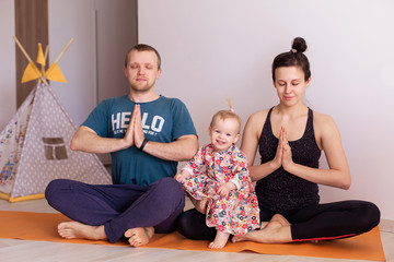 Full young family goes sports at home togetherness. Mom dad baby kid doing yoga exercises. Love harmony idyll.  Leisure healthy lifestyle. Activity morning. mental health resilience contented emotion 