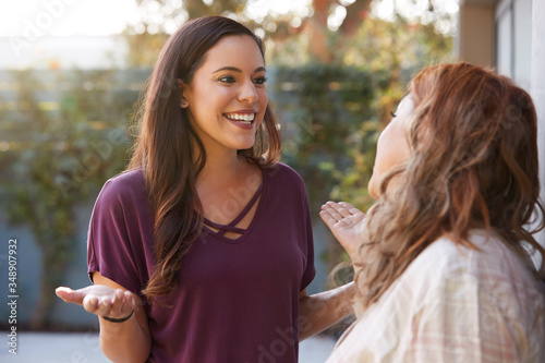 Photographie Senior Hispanic Mother Talking And Laughing With Adult Daughter In Garden At Hom