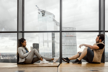 Wall Mural - A couple sitting together by huge glass window, but thinking about different things, London, UK