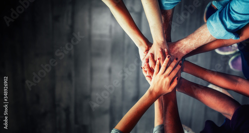 Cuadros en Lienzo Close up top view of young business people putting their hands together