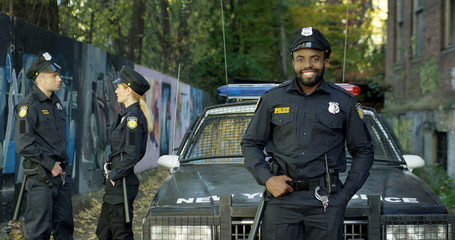 Happy and smiling African American police officer looking at camera