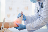 Asian orthopedist or orthopedic doctor Wear a surgical mask and medical gloves. We are examining the cause of the ankle bone.