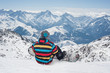 © guruXOX - Snowboarder sitting on the top of mountain, enjoying the view