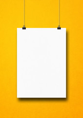 Poster - White poster hanging on a yellow wall with clips