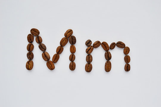 letters m made of coffee beans on the white background