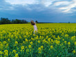 © Irina Anashkevich - Beautiful blonde girl in a rape field before the storm. Girl and flowers.