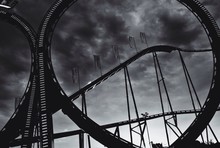 Low Angle View Of Rollercoaster Ride Against Cloudy Sky