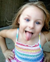 High Angle View Of Cute Girl Sticking Out Tongue