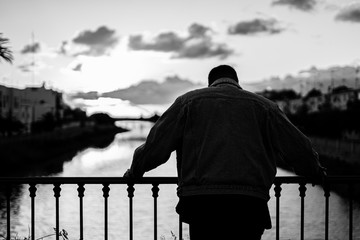 Chico pensando puente rio agua luz nubes blanco y negro