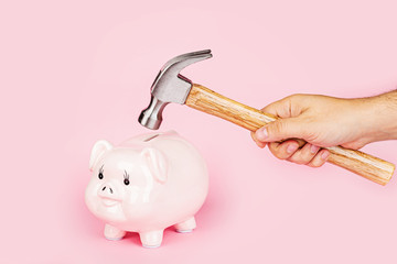 Wall Mural - Men's hand smashes with a hammer Piggy bank on pink background. mockup, template. Concept of financial crisis after coronavirus covid-19 pandemic