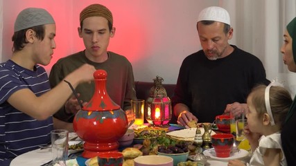 Wall Mural - Muslim Family Eating Dinner At Home. Ramadan is a time when families get together in the evening to break their fast