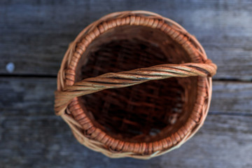 Wall Mural - Ancient wicker basket on a wooden background. Selective focus