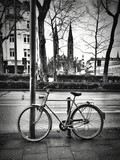 Fototapeta Uliczki - Bicycle By Bollard On Sidewalk In City