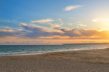 Wall Mural - Landscape of beautiful sunset on the ocean, with sand, horizon with a blue sky. Portugal.