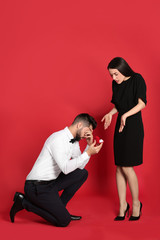 Wall Mural - Young woman rejecting engagement ring from boyfriend on red background