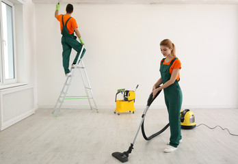 Wall Mural - Professional young janitor vacuuming indoors. Cleaning service