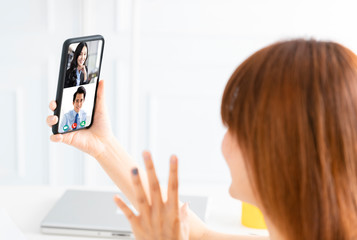 young woman working at home and using mobile phone  with video chat