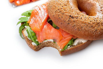 Wall Mural - bitten bagel sandwich with salmon on white background