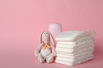 Wall Mural - diapers and baby accessories on pink background, space for text