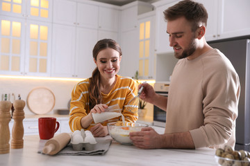 Poster - Lovely young couple cooking dough together in kitchen