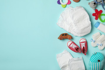 Wall Mural - diapers and baby accessories on light blue background, flat lay. space for text