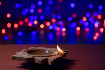 Wall Mural - Diya lamps lit with bokeh background during diwali celebration