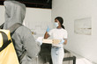 © LIGHTFIELD STUDIOS - african american girl in medical mask and latex gloves taking boxes with pizza from delivery man