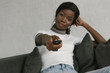 © LIGHTFIELD STUDIOS - selective focus of african american girl holding tv remote controller at home