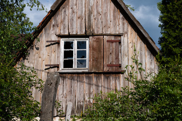 old wooden house in the green with broken window