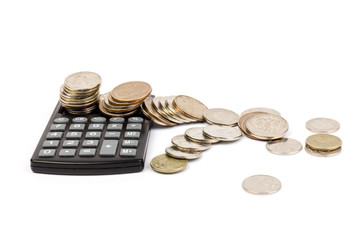 The stack of coin with calculator on white background, concept of calculating expenses, incomes and expenses.