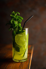 Mojito cocktail with lime and mint on the rustic background. Selective focus. Shallow depth of field.