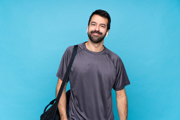 Young sport man with beard over isolated blue background laughing