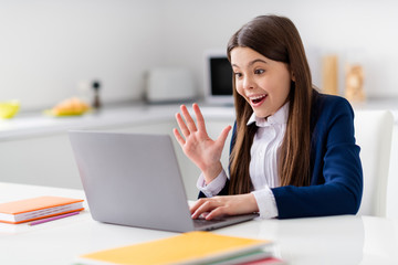 Canvas Print - Photo of little cheerful student girl school student notebook online video call sit desk missing talking friends classmates distance quarantine study home living room house classroom indoors