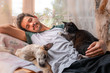 © magui RF - hombre joven duerme junto a un perro y un gato negro en un sillon  bajo una mosquitera.