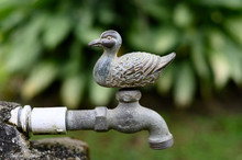 Close Up View Of A Decorative Vintage Water Faucet In A Home's Garden, Made Out Of Brass In The Shape Of A Duck.