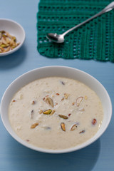 Wall Mural - Kheer or Payasam is a type of rice pudding from the Indian subcontinent, made by boiling milk and sugar and is flavoured with dry fruits and nuts, served in ceramic bowl.