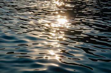 Wall Mural - Seascape background sun's rays reflect on sea surface at sunset