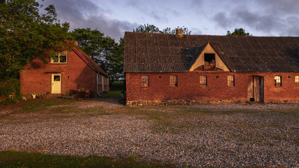 The old farm buildings of a typical Danish homestead in the setting sunlight