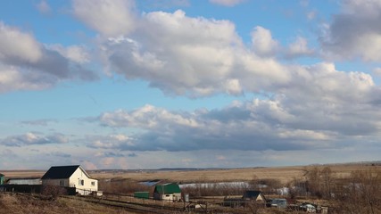 Wall Mural - Timelapse video clouds moving quickly over a small village or private houses