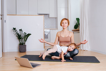 Wall Mural - Toddler napping on his mother's legs while she is doing yoga at home