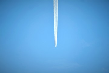 Airplane in the blue sky leaving trail