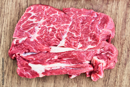 Photo Slice of raw beef steak on wooden cutting board