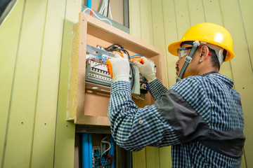Fototapete - Electrician at work at House,Electrician repairing electrical box with pliers in corridor of a residential electrical system.