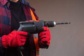 Poster - Electric drill in the hands of a man close-up. A tool for constr