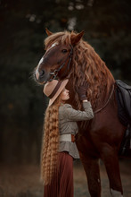 Beautiful Long-haired Blonde Young Woman In English Style With Red Draft Horse In Autumn Forest