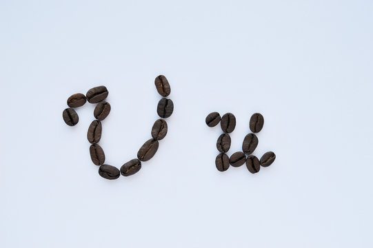 Uppercase letters u made of coffee beans on the white background