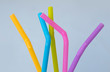 Colorful plastic straws on blue background